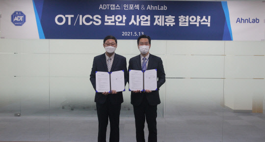 최명균(왼쪽) ADT캡스 인포섹 사업2본부장과 김학선 안랩 사업부문장이 업무 협약식을 마치고 기념 촬영을 하고 있다. ADT캡스 제공